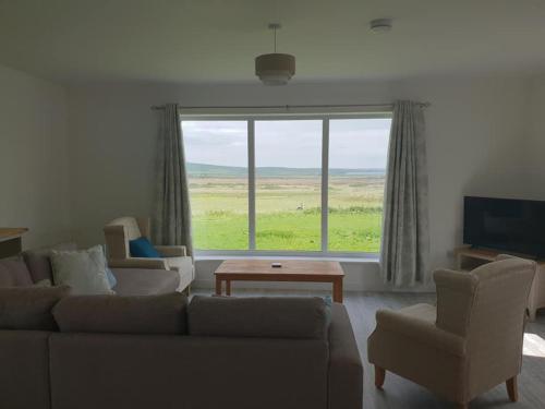 FinstownCottiscarth Cottages的带沙发和椅子的客厅以及大窗户。