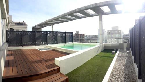 拉普拉塔Land Plaza La Plata的一座带游泳池的屋顶甲板,位于一座建筑中
