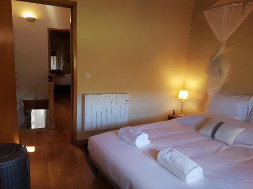 MontezinhoAbrigo Montesinho的卧室配有一张带两个枕头的大白色床