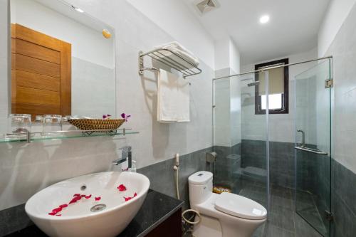 会安Hoi An Impression Homestay的一间带水槽、卫生间和玻璃淋浴间的浴室