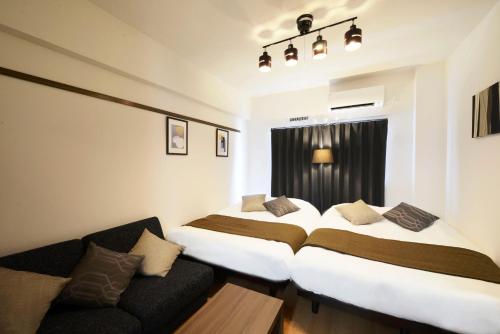 冲绳岛市Allstay GOYA的酒店客房,设有两张床和一张沙发
