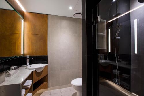 利物浦悉尼利物浦美居酒店的浴室配有2个盥洗盆、卫生间和淋浴。