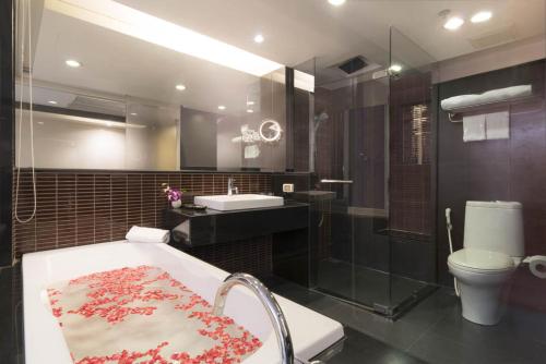 曼谷Furama Silom Hotel的带浴缸、盥洗盆和卫生间的浴室