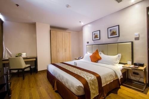 马尼拉ACE套房酒店 的酒店客房设有一张大床和一张书桌。