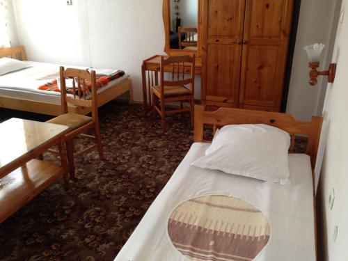 斯莫梁卡捷琳娜家庭旅馆的一间设有两张床和一张桌子及椅子的房间