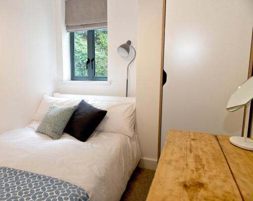 福伊Fowey Landing的卧室配有白色的床和窗户。