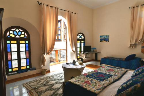 梅克内斯Riad Dar AlKATIB Meknès的一间卧室设有一张床和两个窗户。
