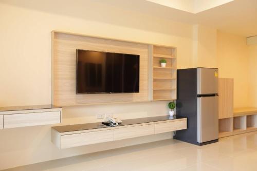 南邦Lampang Residence的带冰箱的厨房和平面电视。