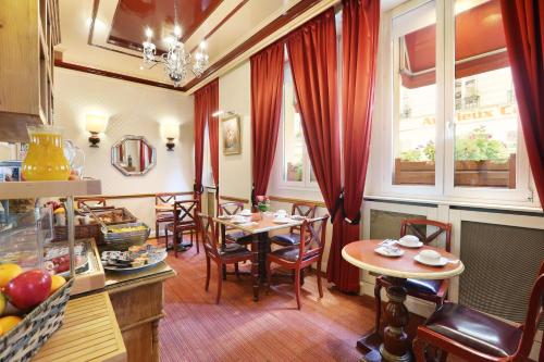 巴黎法兰西学院酒店的厨房以及带桌子和窗户的用餐室。