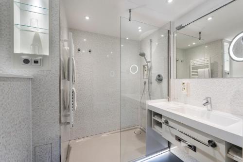 柏林柏林埃斯特酒店的一间带玻璃淋浴和水槽的浴室