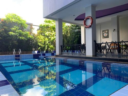 安汶Pacific Hotel Ambon的蓝色瓷砖的游泳池和房子