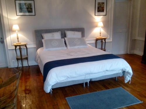 Neufmoutiers-en-BrieChambres d'hôtes La Bourbelle的一间卧室配有一张大床和两盏灯