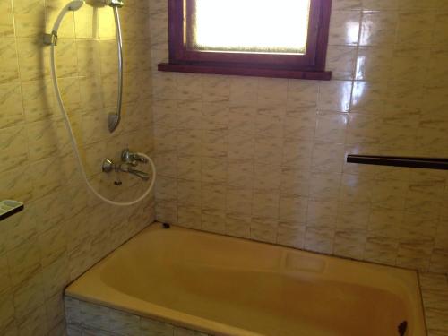 斯莫梁卡佳宾馆的带浴缸的浴室和窗户