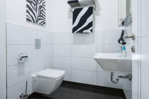 曼海姆高层公寓的白色的浴室设有卫生间和水槽。