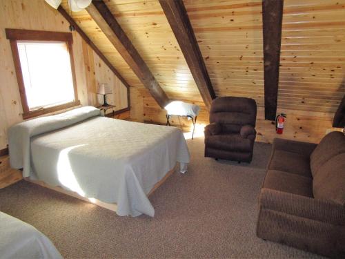希尔城Freedom Ridge Cabins的小屋内一间卧室配有一张床和一把椅子