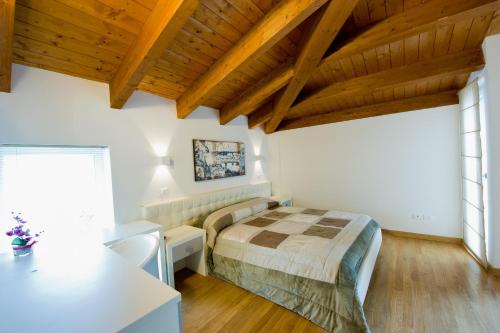 佩斯卡拉朱莉住宿加早餐旅馆的一间带一张床的卧室,位于带木制天花板的房间内