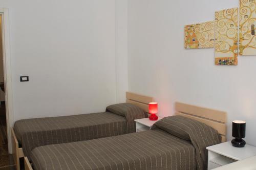热那亚Perdiana House的一张桌子上放着红色蜡烛的房间里,有两张床