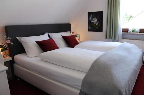 纽伦堡Hotel Daucher的一间卧室配有两张带红白色枕头的床