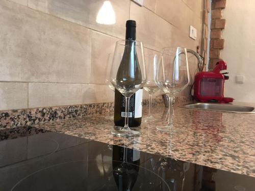 罗塔Casa Maria的一瓶葡萄酒和两杯酒杯坐在柜台上
