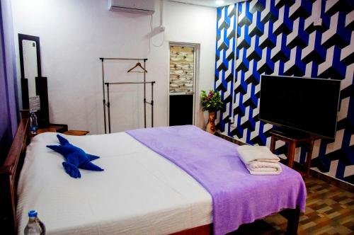 AmbanpolaHotel Chanaya的一间带大床和电视的卧室