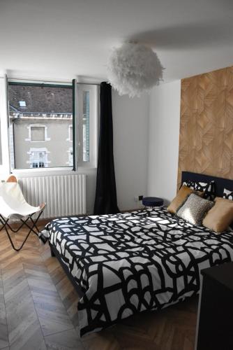 布雷斯地区布尔格LE SELECT DE BROU的卧室设有黑白床和窗户。