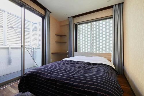 东京Kyodo House的一间卧室设有一张床和一个大窗户