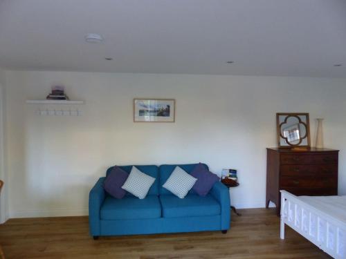 格拉斯顿伯里Littlemead - Newly renovated private studio near Glastonbury的客厅配有蓝色沙发,设有床