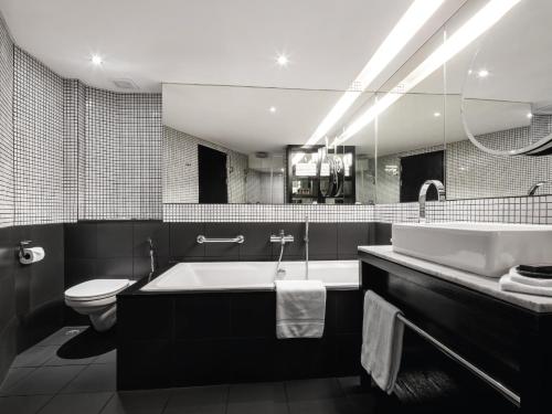 芭堤雅市中心Hard Rock Hotel Pattaya的带浴缸、卫生间和盥洗盆的浴室