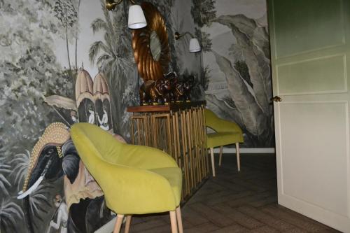 阿克托比Ayhan Hotel的一间设有两把椅子和壁画的墙壁的房间