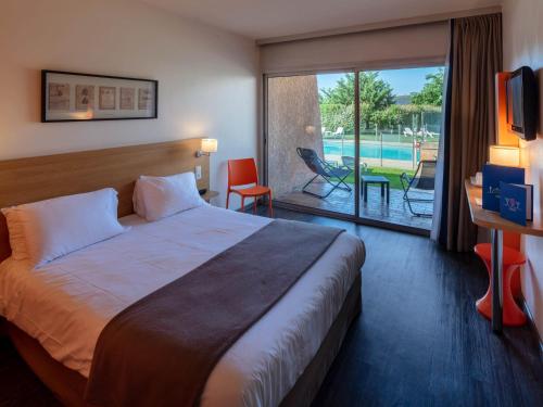 拉瓦雷特迪瓦尔Noemys Toulon La Valette - Hotel restaurant avec piscine的酒店客房设有一张床和一个带游泳池的阳台