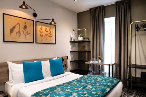 巴黎Hôtel Maxim Quartier Latin的一间卧室配有一张带蓝色枕头的床