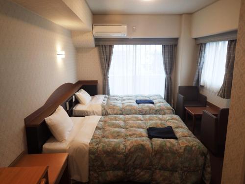 小牧市小牧城堡旅馆的酒店客房设有两张床和窗户。