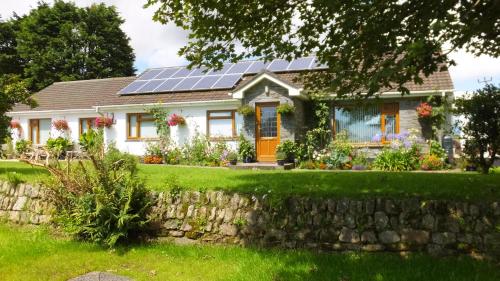 赫尔斯顿Rose Vean Bed & Breakfast的屋顶上设有太阳能电池板的房子