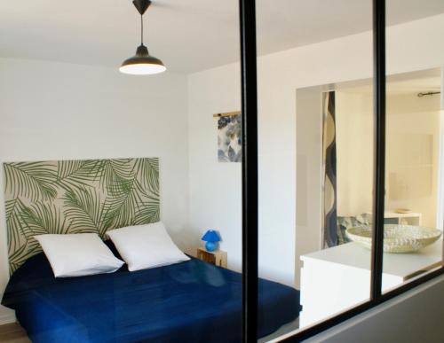 勒布伊Gîte du rocher的一间卧室配有蓝色的床和镜子