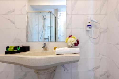 布尔加斯Marina Burgas Hotel的一间带水槽和镜子的浴室