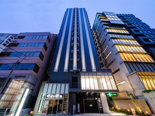 大阪UNIZO INN Osaka Kitahama的一座高大的蓝色建筑,两座高大的建筑