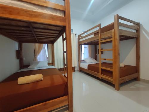 珀尼达岛Gedhong Hostel的两张双层床,位于带性关节炎性关节炎性关节炎性关节炎性关节炎的房间