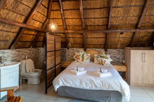 布隆方丹Lala Dene Lodge的一间卧室配有一张床,一间卫生间位于客房内
