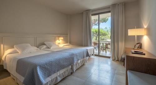 萨卡罗萨加罗健康水疗酒店的酒店客房设有两张床和大窗户。