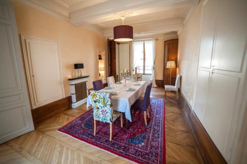 沙布利Maison des 7 lieux的一间位于地毯上的带桌椅的用餐室