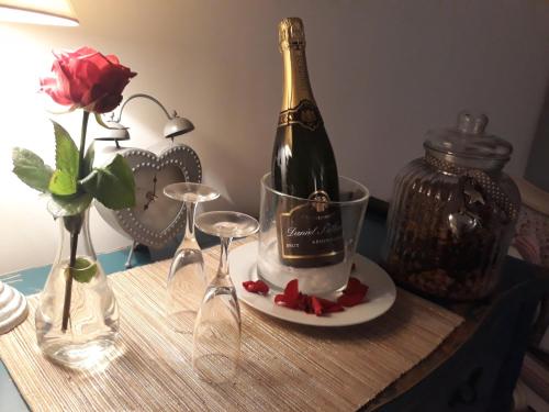 Neufmoutiers-en-BrieChambres d'hôtes La Bourbelle的一张桌子上摆放着一瓶香槟酒和酒杯