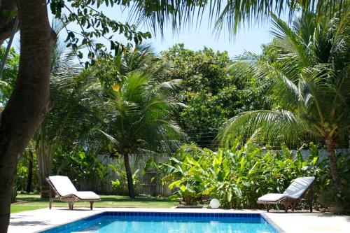 帕拉茹鲁Refugios Parajuru - Casa Verde的一个带两把椅子的游泳池,棕榈树