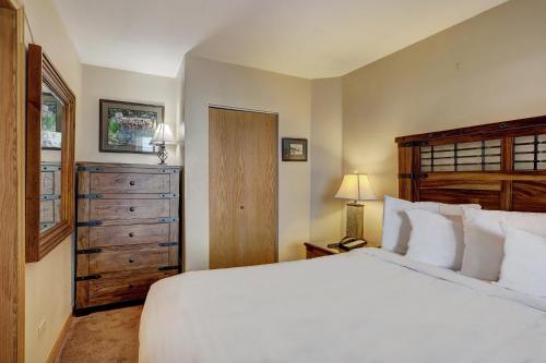 布雷肯里奇River Mtn Lodge W103的卧室配有白色大床和梳妆台