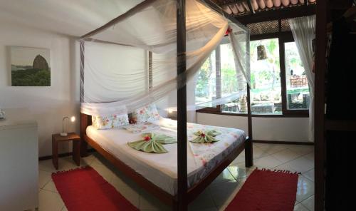 帕拉茹鲁Refugios Parajuru - Casa Verde的一间卧室设有天蓬床和窗户。