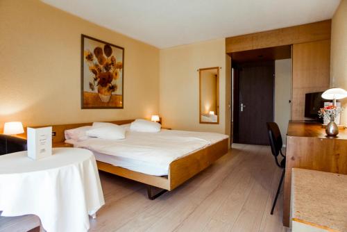 德莱蒙勒纳申尔酒店的酒店客房配有一张床铺和一张桌子。