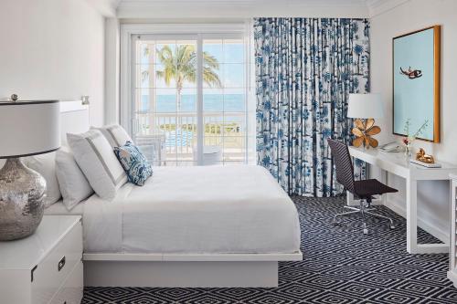 马拉松Isla Bella Beach Resort & Spa - Florida Keys的一间卧室配有一张床、一张书桌和一个窗户。