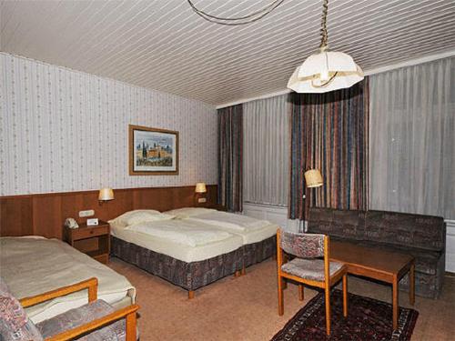 汉堡滨海大道酒店的一间卧室配有两张床、一张桌子和一把椅子
