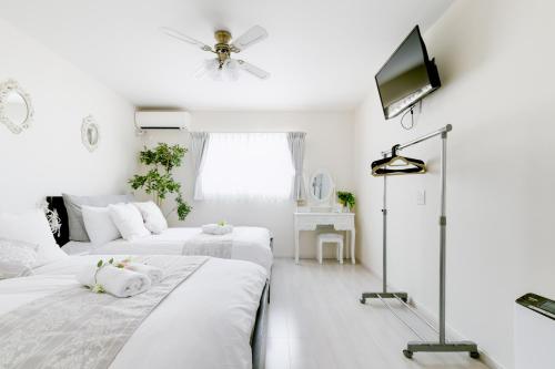 大阪Villa de Class的白色客房的两张床,配有吊扇