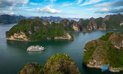 下龙湾Le Theatre Cruises - Wonder on Lan Ha Bay的两岛之间的水面上的游轮
