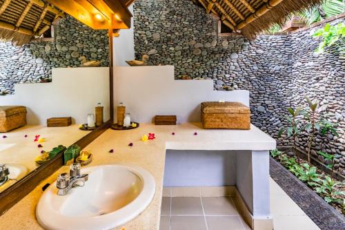 佩母德兰塔曼塞里尼瓦哈纳海滩度假酒店的一间带水槽和石墙的浴室